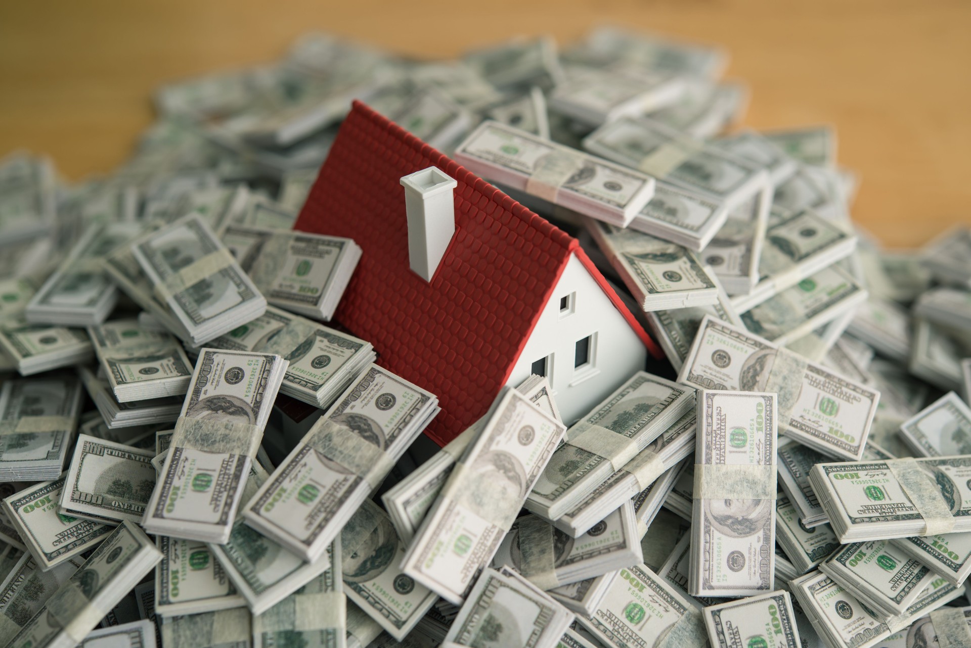 A house drowning in heap US dollar banknotes. A house drowning in heap US dollar banknotes.